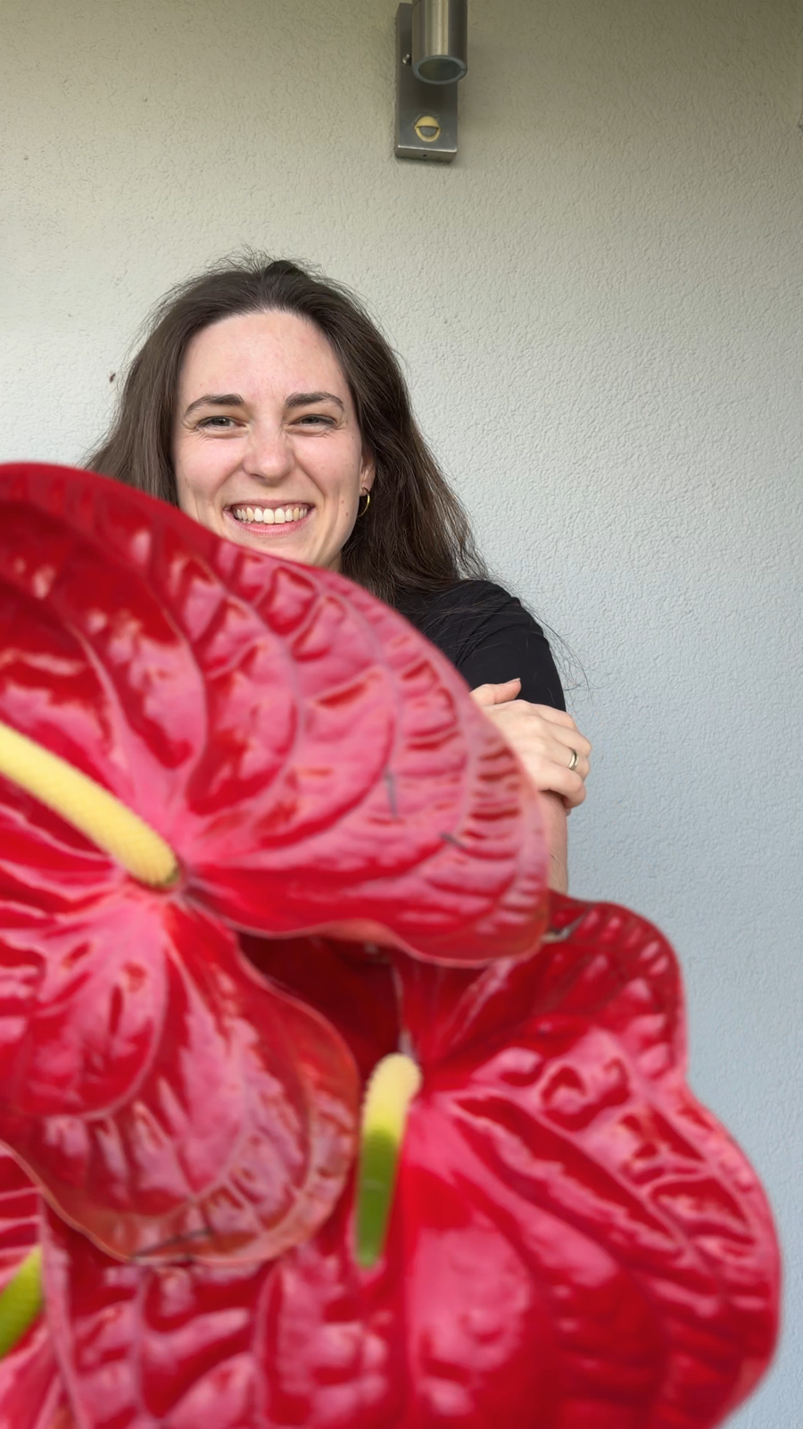 Jana Oettlin lacht hinter roten Blumen