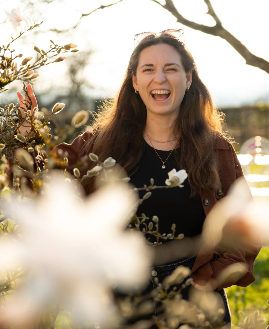 Jana Oettlin lachend zwischen Blüten