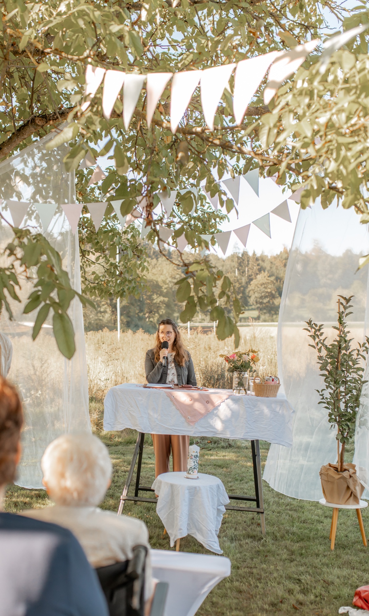 Jana Oettlin hält eine Rede bei einem Kinderwillkommensfest im Garten